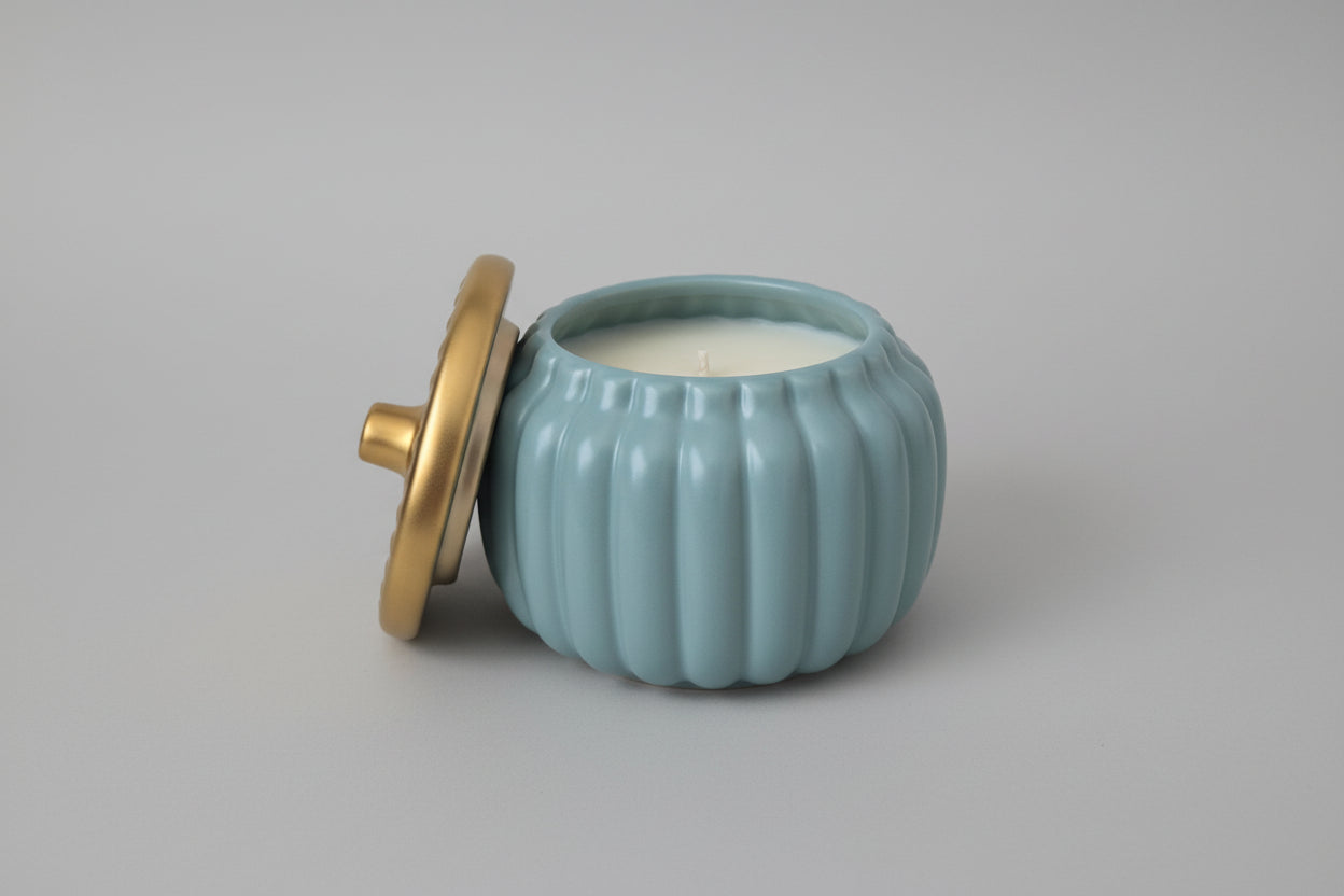 Light blue ceramic jar with a gold lid on a white surface
