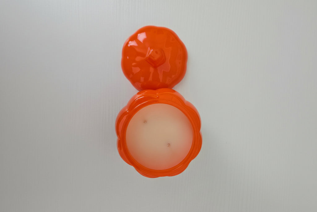 Orange lip balm container with a white background