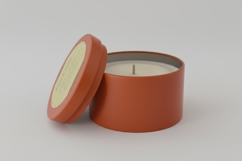 Candle in a terracotta container on a light gray background