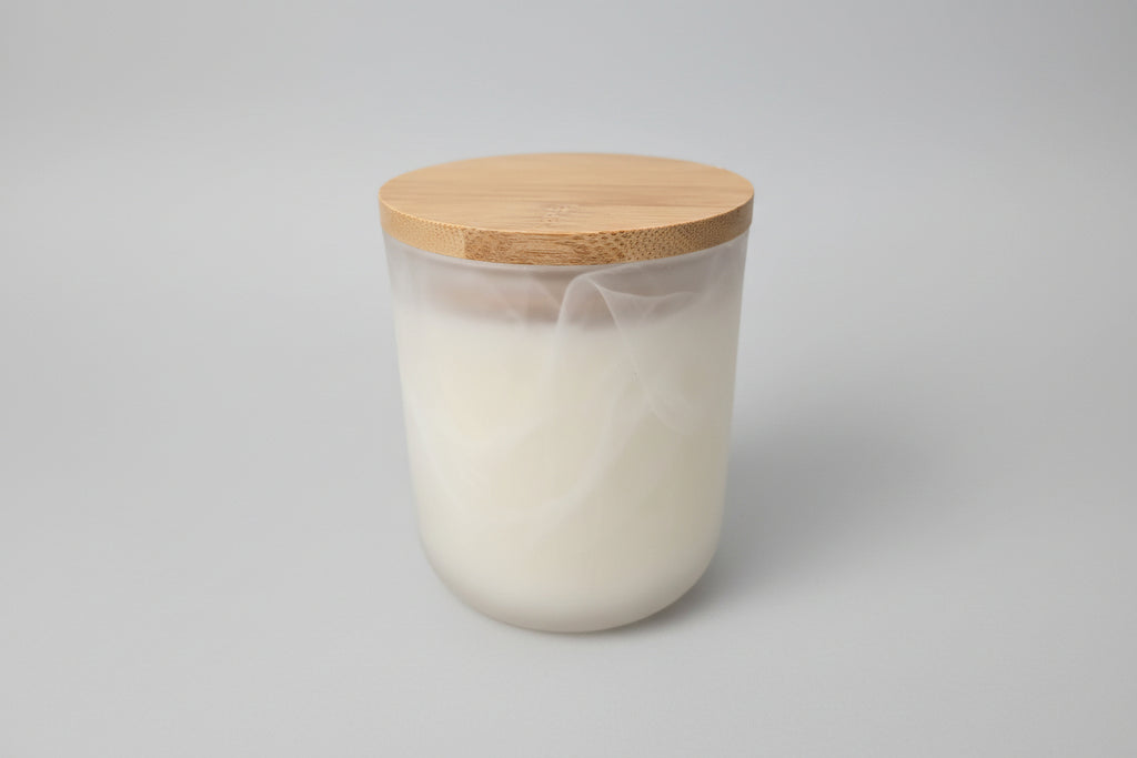 White container with a wooden lid on a white surface