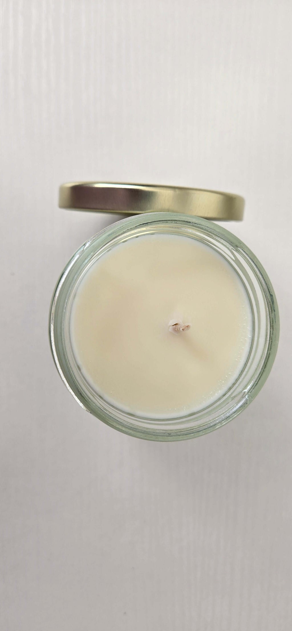 Candle in a glass jar with a metal lid on a white background