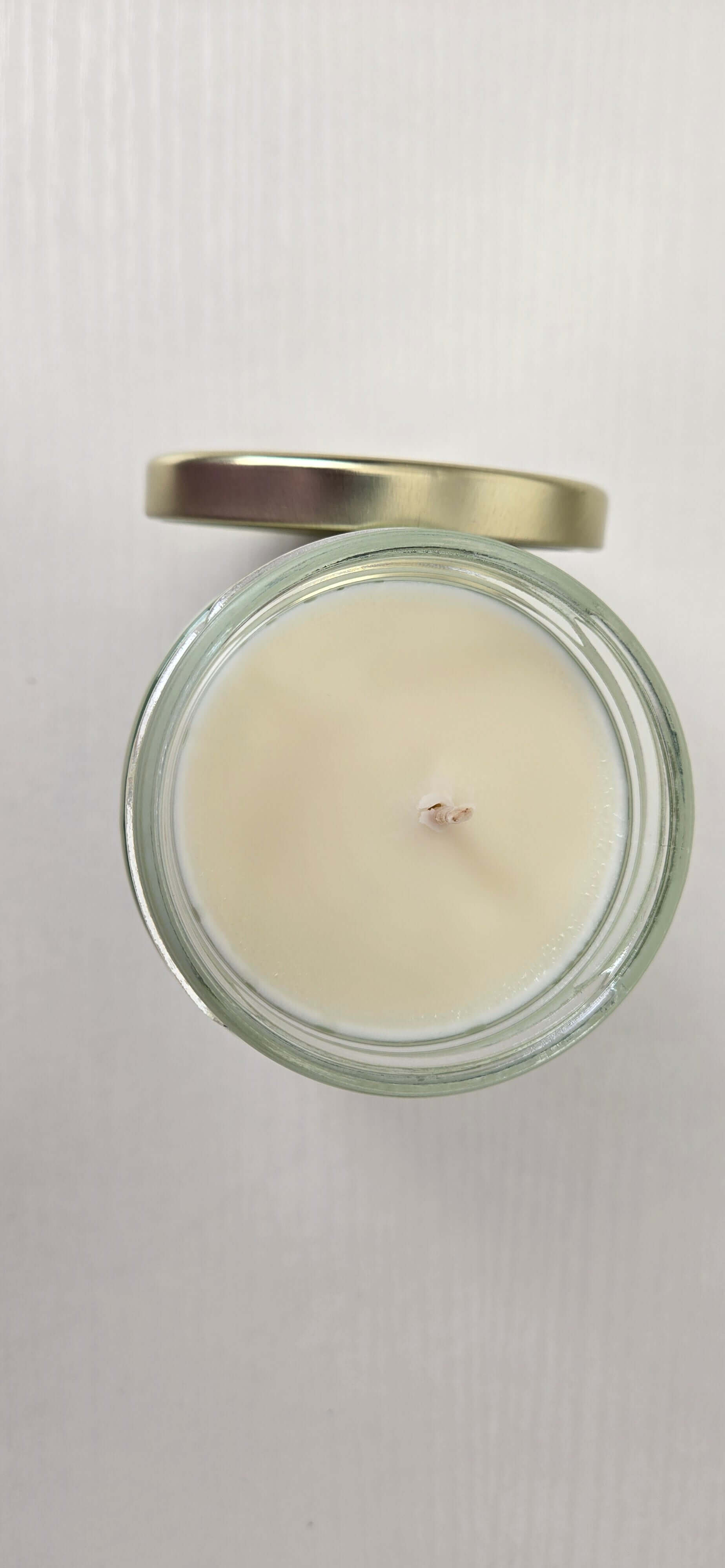 Candle in a glass jar with a metal lid on a white background