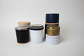 Set of black, gold, and white tape rolls on a white surface