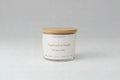 Candle with wooden lid on a white background